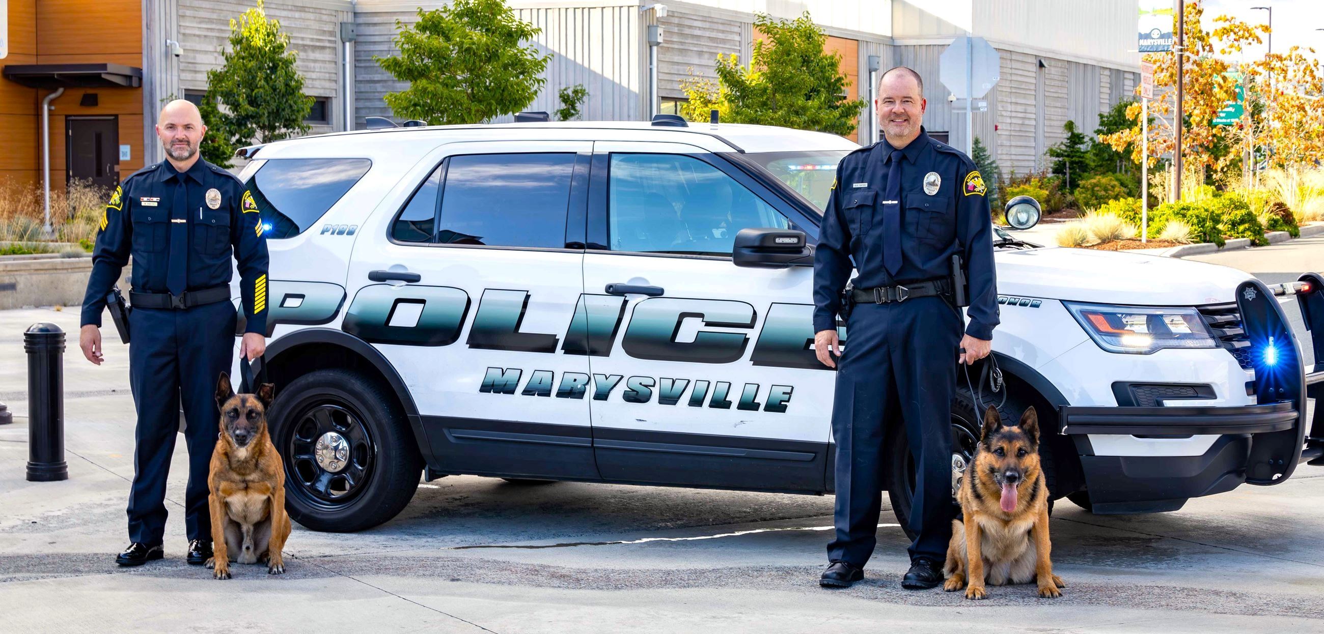 K-9 Unit group photo shows Ofc. Brad Smith and Steele alongside Ofc. Derek Oates and Copper