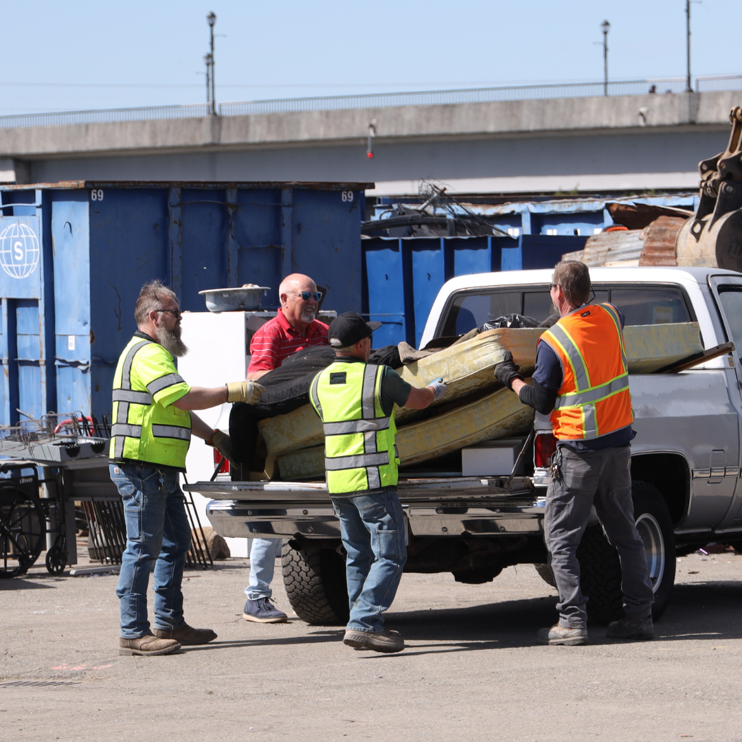 City workers helping unload items from truck bed at Clean Sweep in Marysville, 2024. 