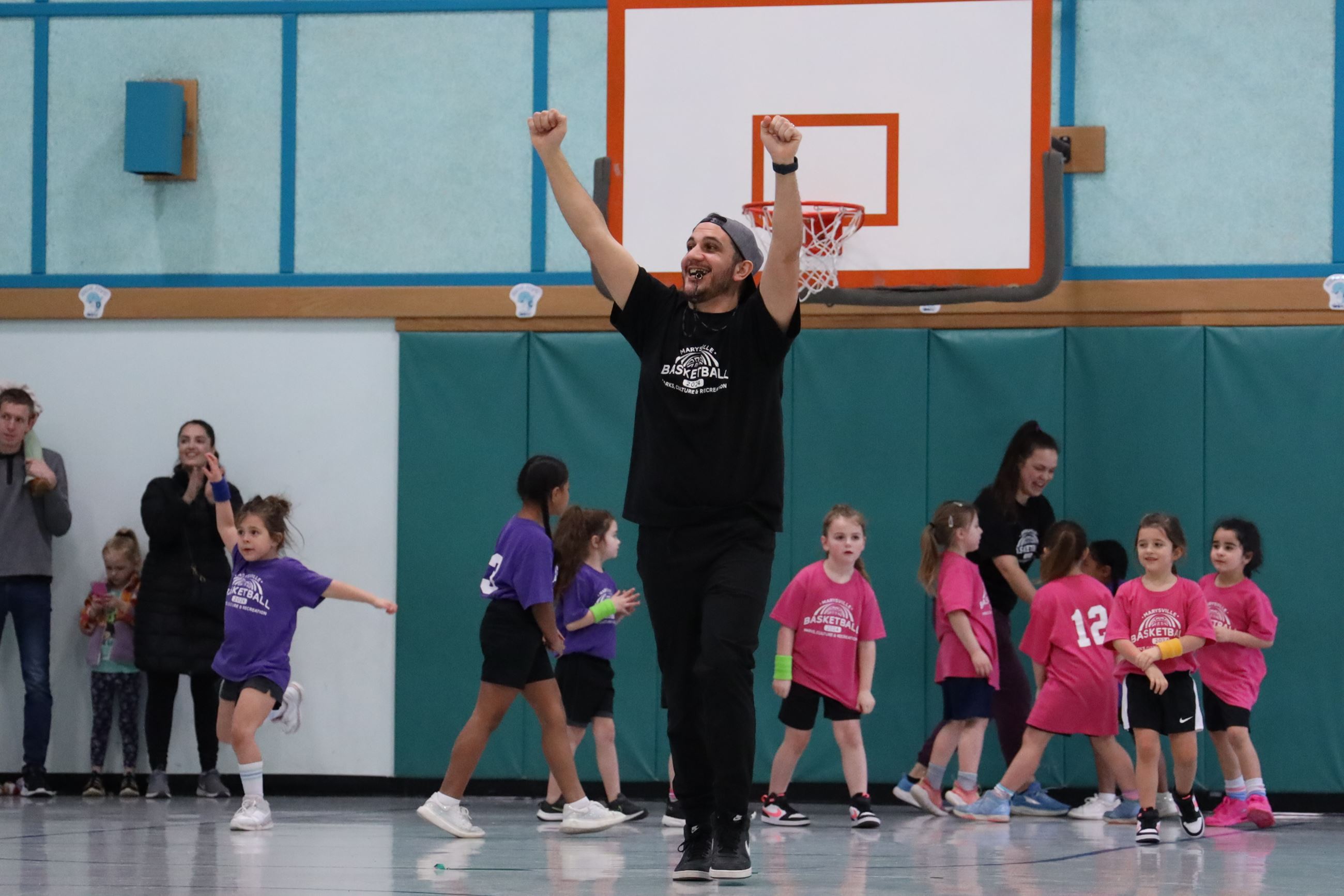 A basketball volunteer coach celebrating at a basketball game