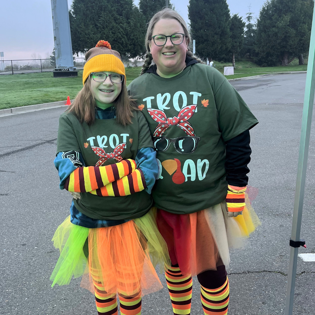 Woman and girl wearing striped leggings, tutus and turkey shirts for Turkey Trot 5K in Marysville