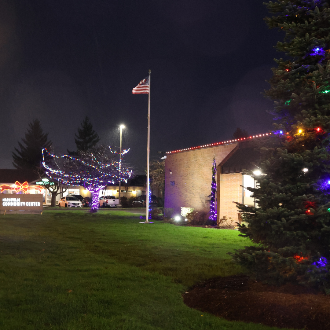 Marysville Community Center at night with lighted Christmas tree, neon sign