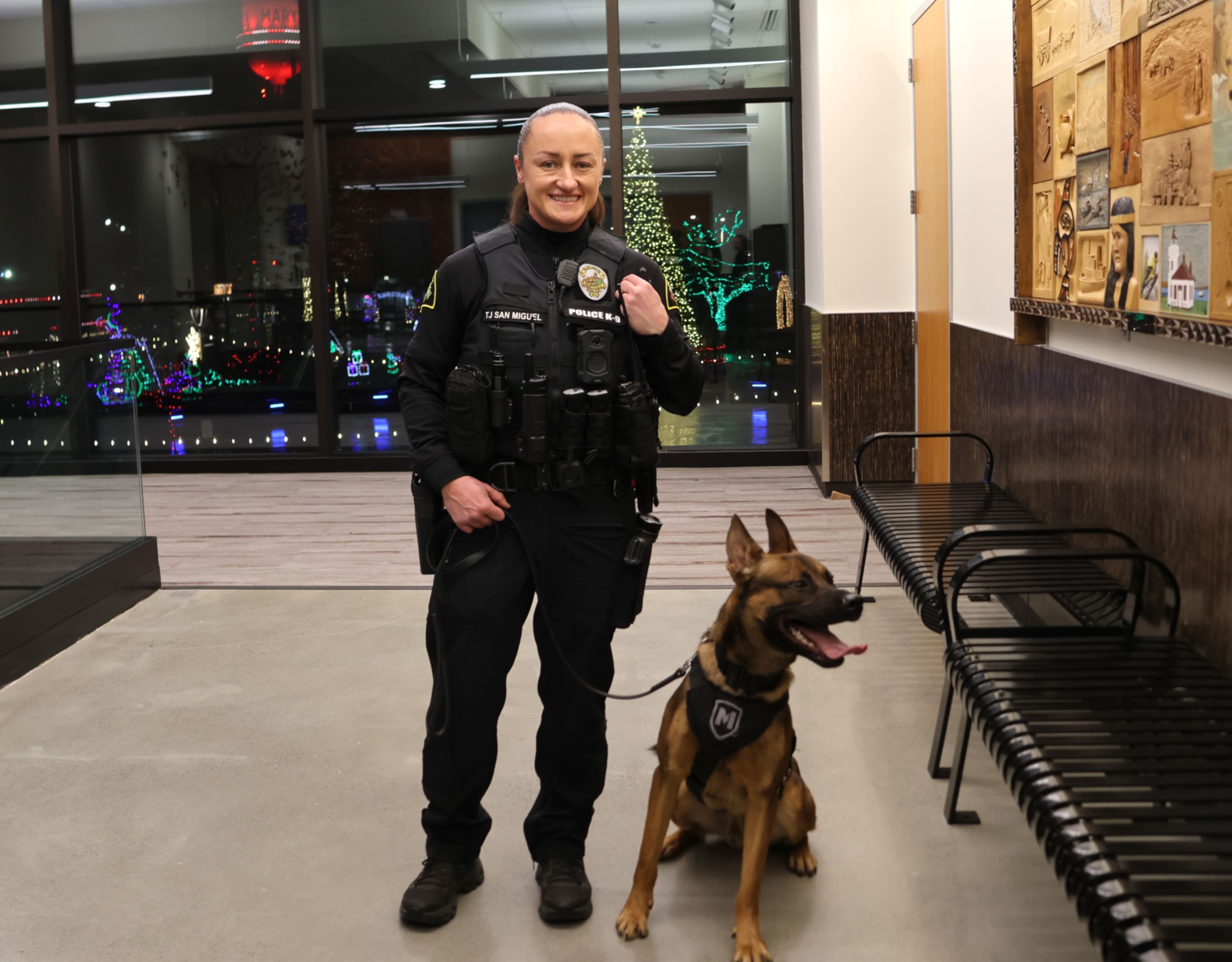 Officer TJ San Miguel standing with K-9 Kona
